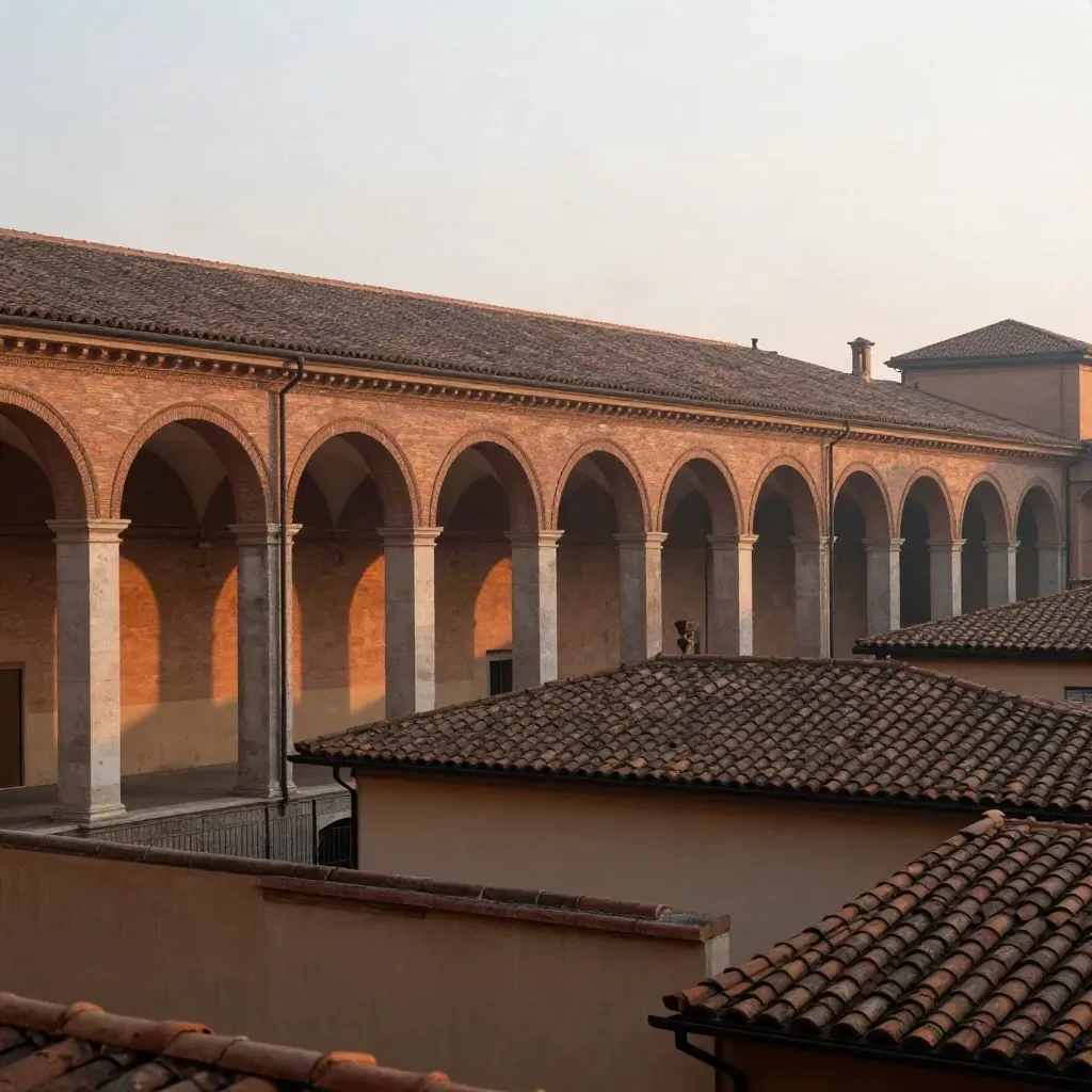I portici di Bologna sopra tetti in cotto e cielo lattiginoso, atmosfera mattutina calma.